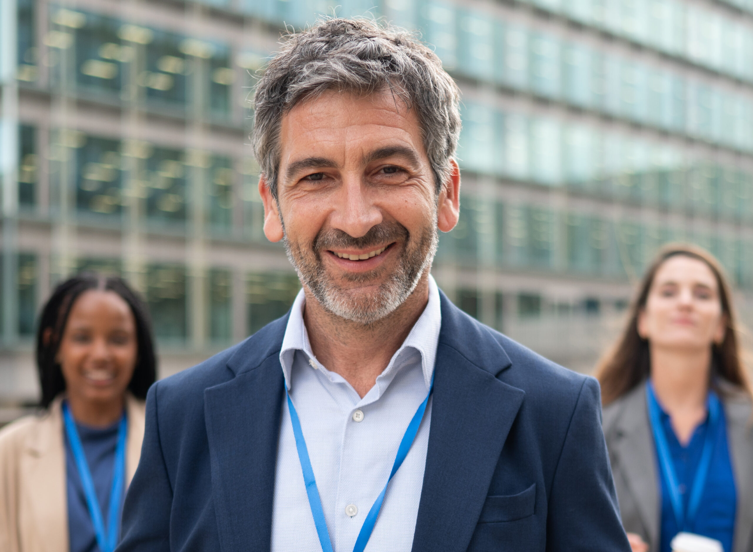 Smiling businessman wearing a blank identification badge at an outdoor corporate event