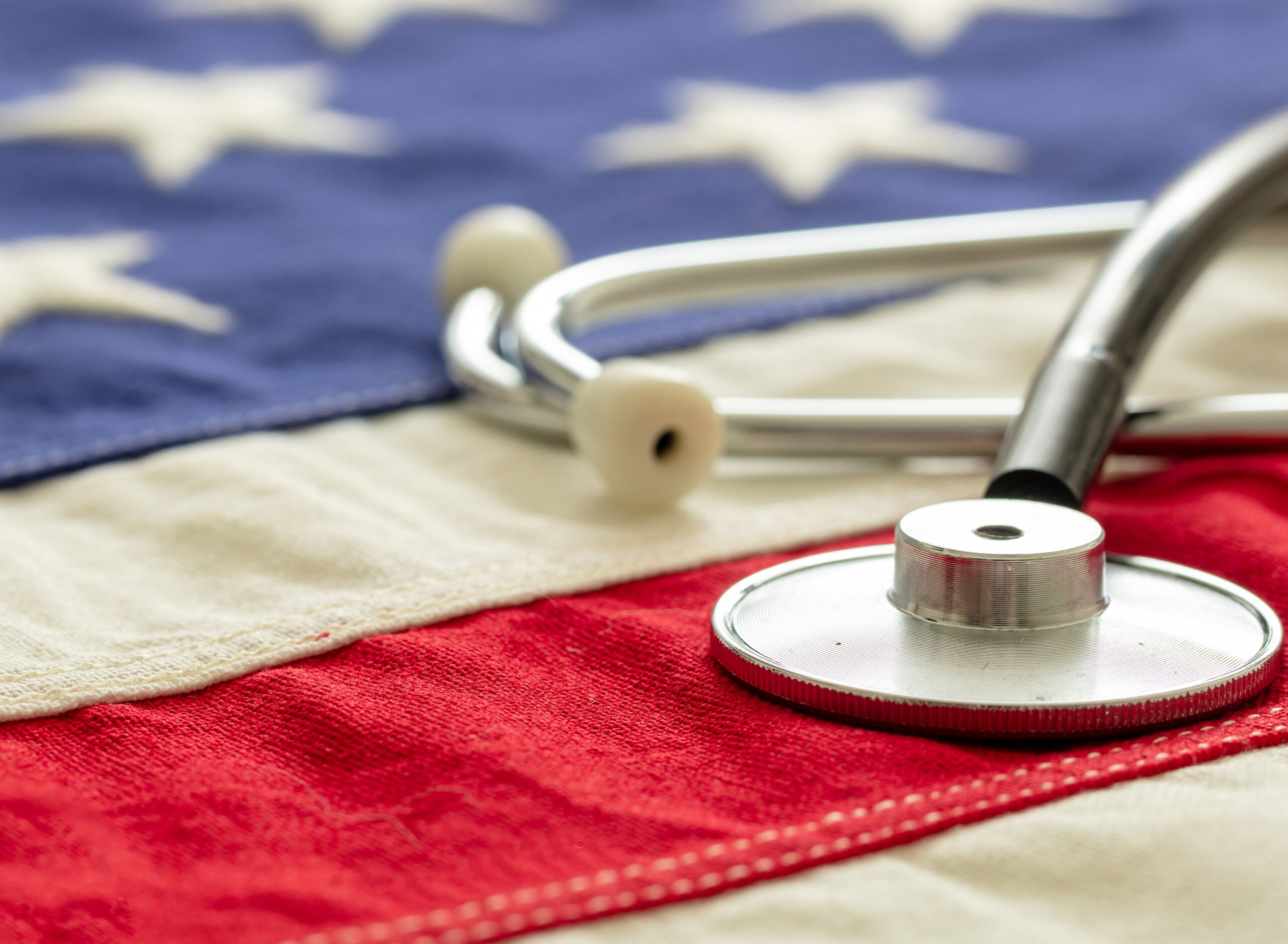 USA health care. Medical stethoscope on a US of America flag, closeup view, banner. American health insurance  concept