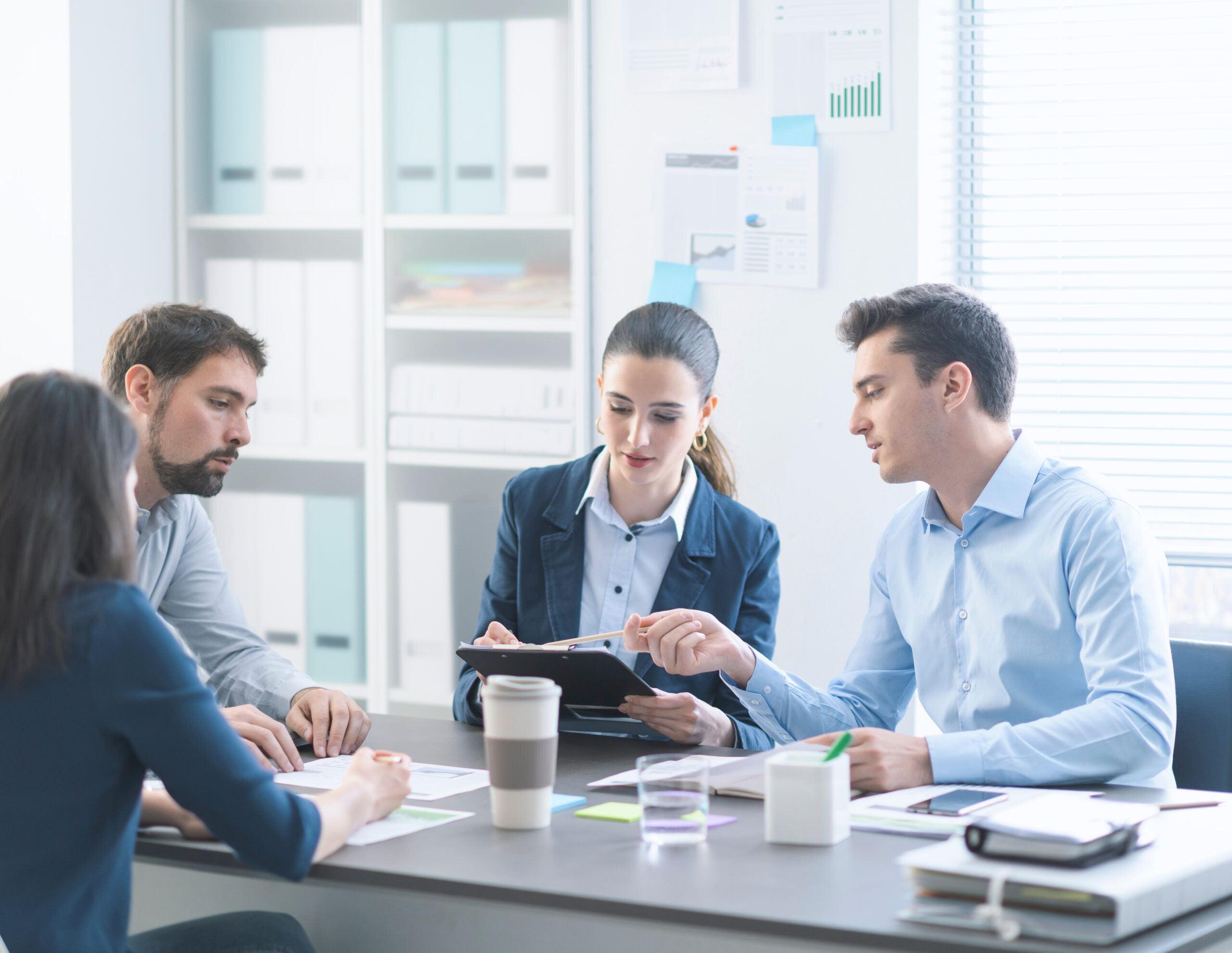 Young professional business team working together in the conference room, they are talking and checking paperwork